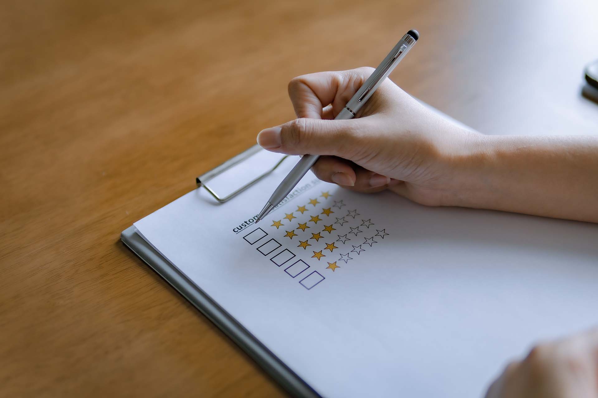 Close-up of a person pressing a five-star rating button, symbolizing customer satisfaction.