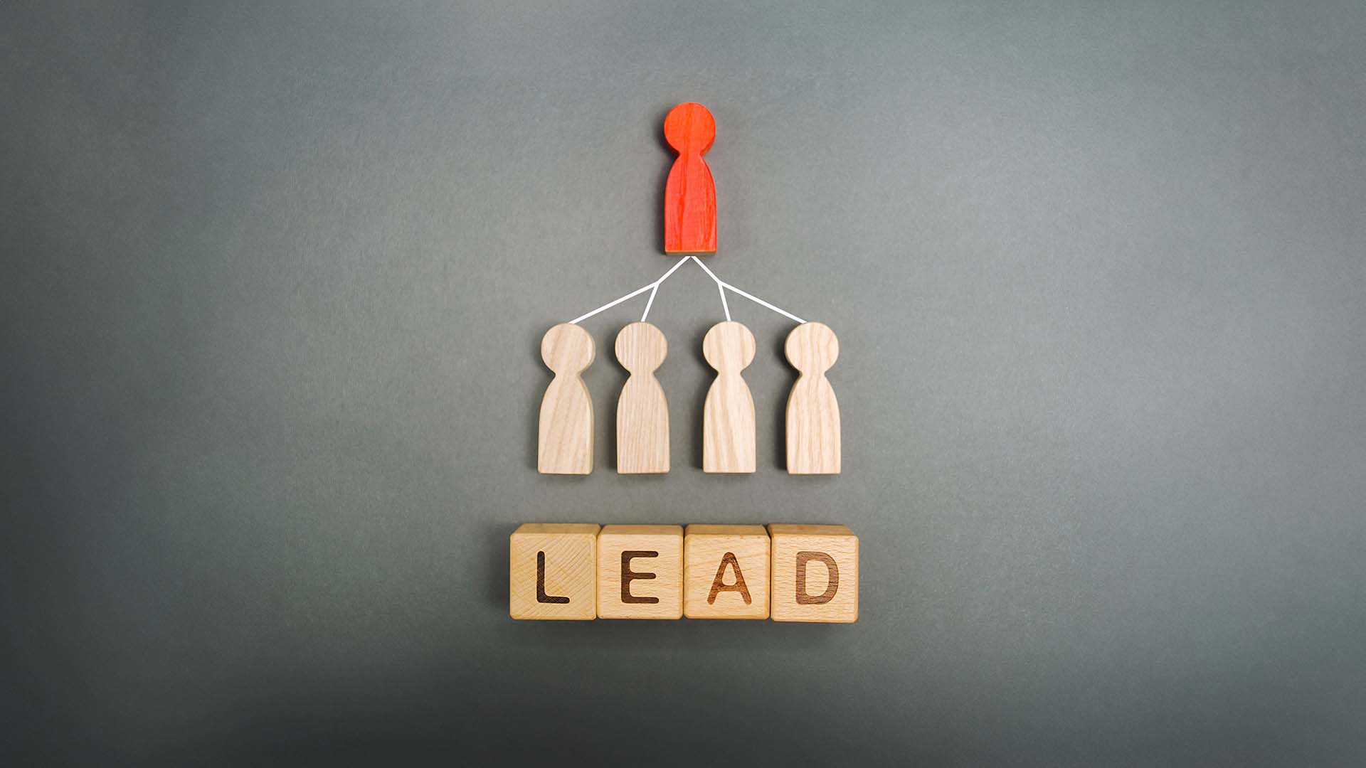 A red figure leading four wooden figures, representing lead generation in a business setting.