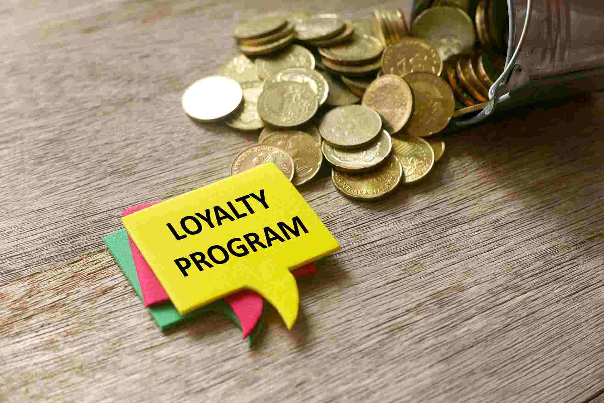 Gold coins spilling out of a container beside a yellow speech bubble labeled "Loyalty Program."