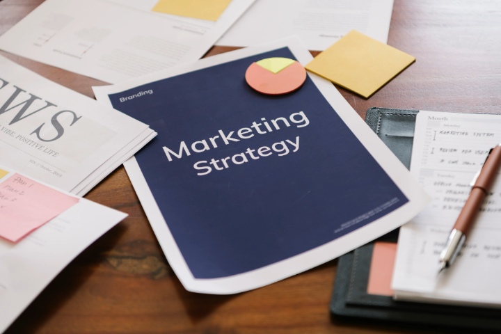 Marketing strategy document on desk with planner, pen, and business notes