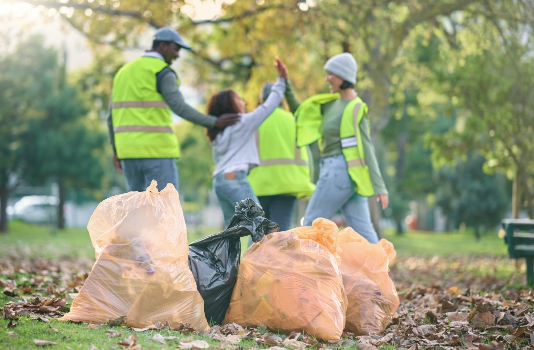 Landscapers Cleaning Up a Lawn During Spring with Trash Bags