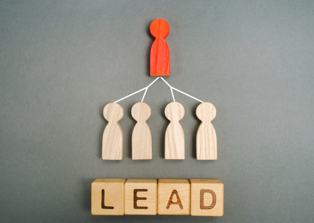 Lead Generation Concept with Wooden Figures and “LEAD” Text Blocks on Gray Background