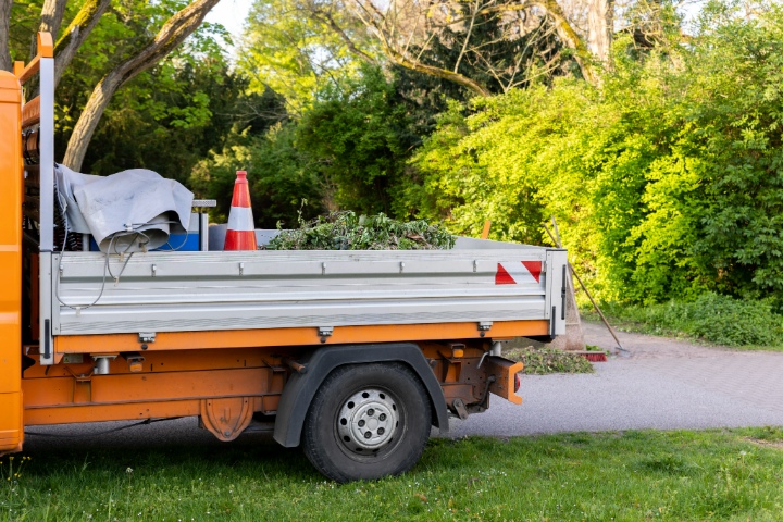 Landscaping truck loaded with yard waste and tools parked during spring cleanup job