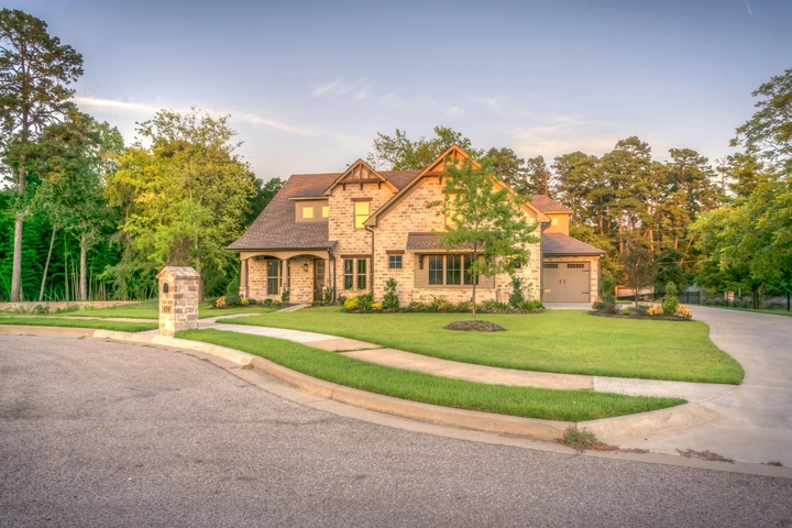 Luxury Brick Home with Manicured Lawn and Driveway in Suburban Neighborhood