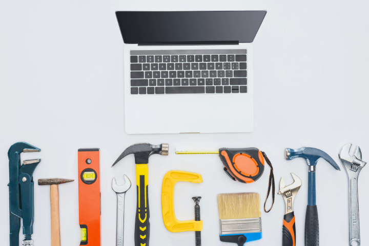 Laptop With Assorted Hand Tools Including Hammers, Wrenches, And Tape Measure