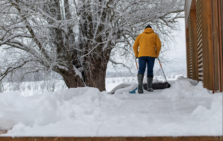 Landscaper With Snow Shovel Cleaning Snow